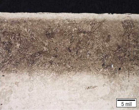 氮化合金組件的金相圖，具有均勻的滲氮層，深度約為0.40毫米（0.016英寸），并且沿表面明顯有淺白亮層。